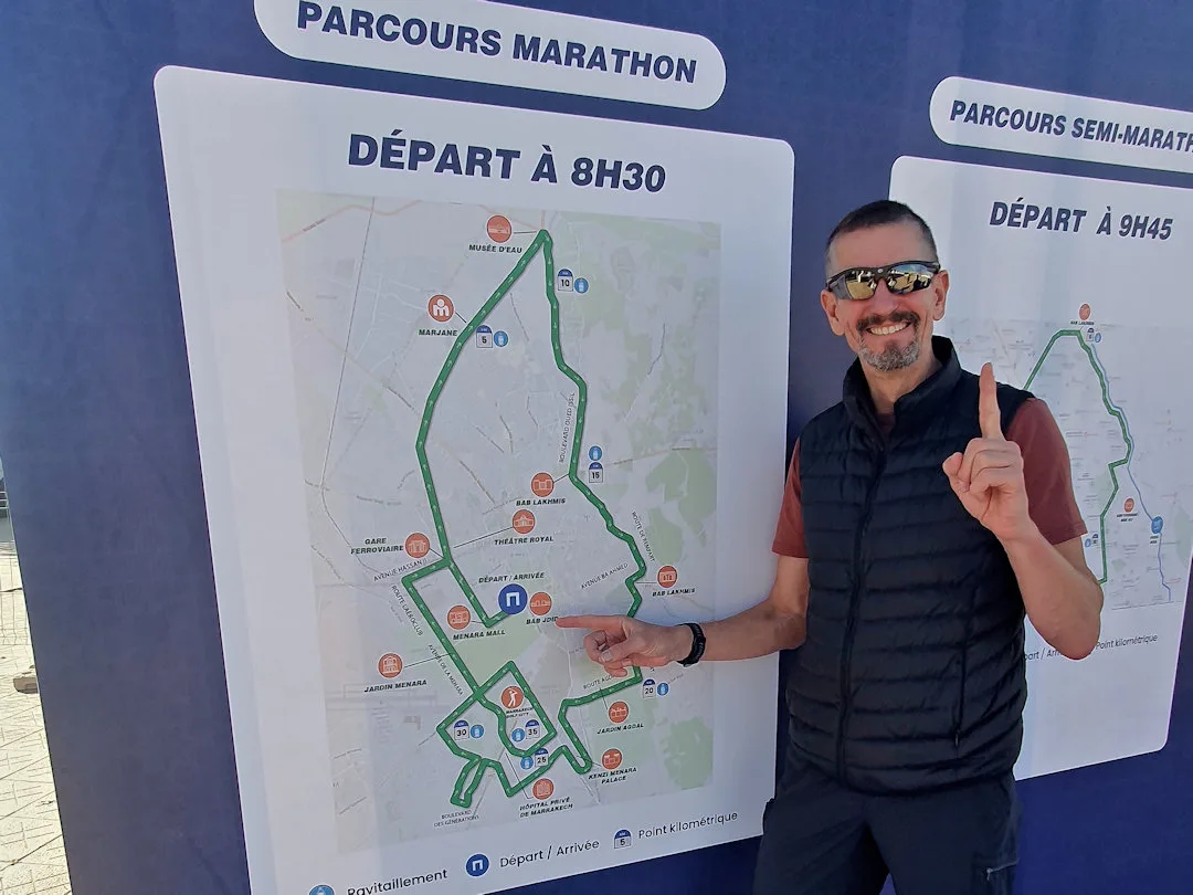 Man pointing at marathon route maps, smiling.