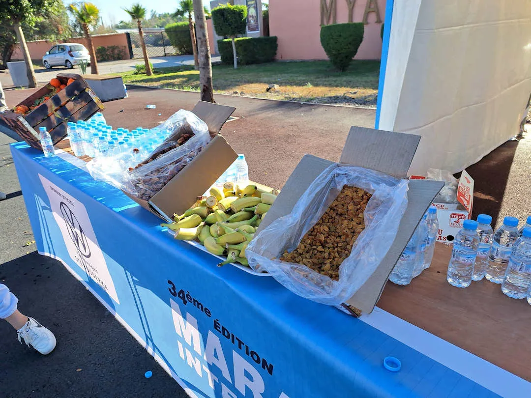 Refreshment table at marathon with fruit, water, and snacks.